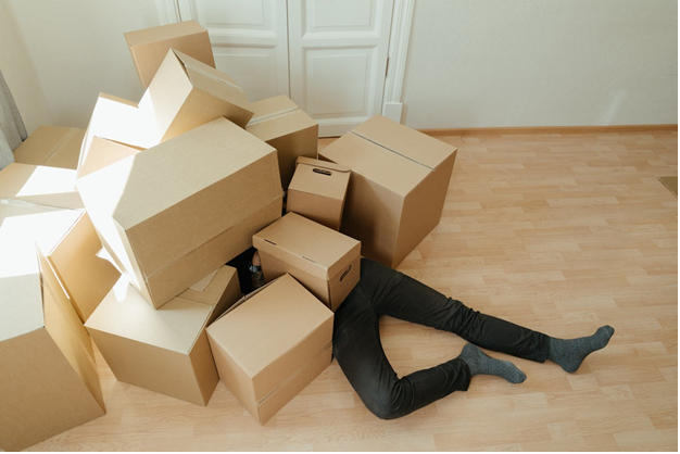 Person under a pile of cardboard boxes